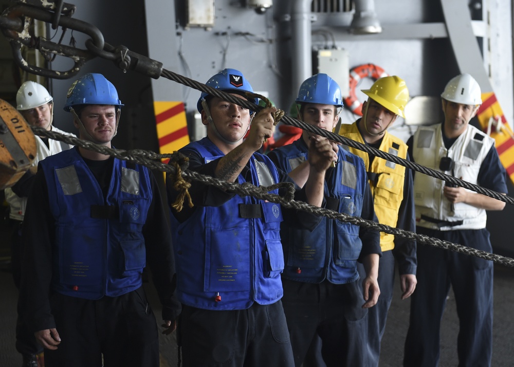 Sailors tend to the spanwire during an underway replenishment