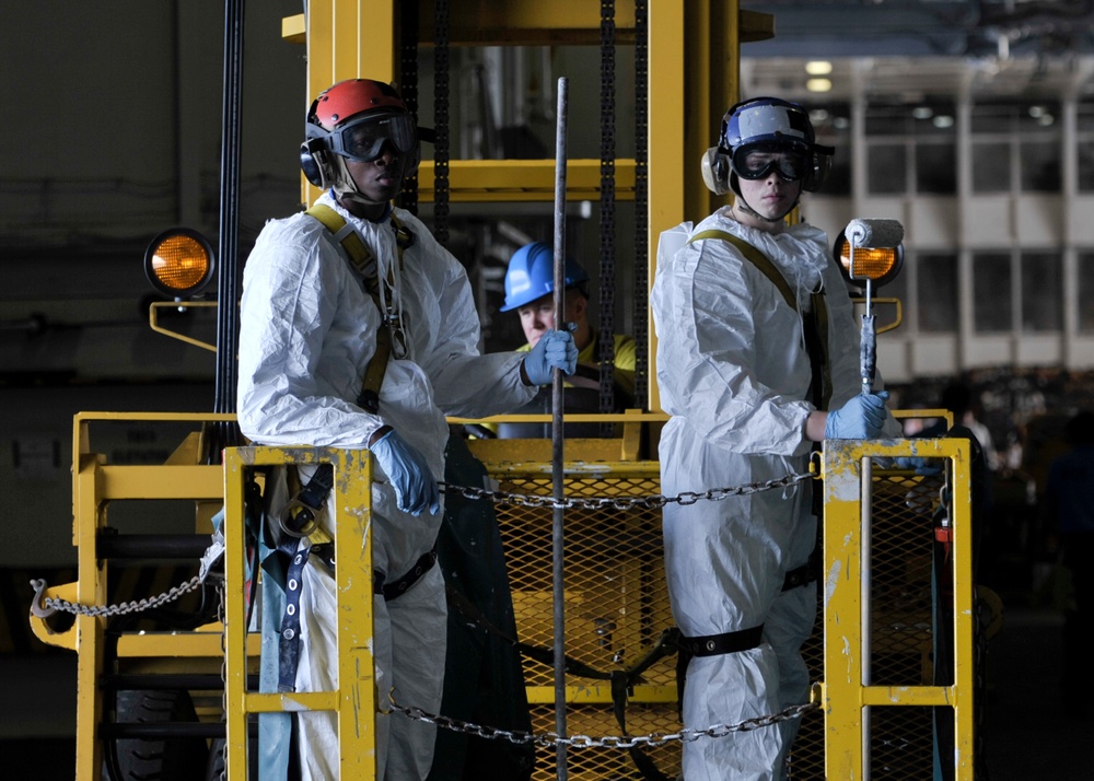 Sailors prepare to paint overhead