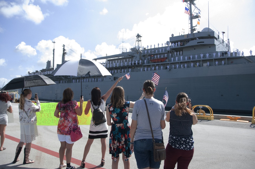 Friends and Family Cheer and Wave at USS Frank Cable at Naval Base Guam in Apra Harbor during the ship's Homecoming Nov. 8.