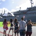 Friends and Family Cheer and Wave at USS Frank Cable at Naval Base Guam in Apra Harbor during the ship's Homecoming Nov. 8.