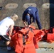 A MST inspects a survival suit on a crabbing vessel