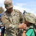 M2 Bradley Fighting Vehicle Crewman Assists a young attendee with combat gear during the Army Vs Irish football game celebration