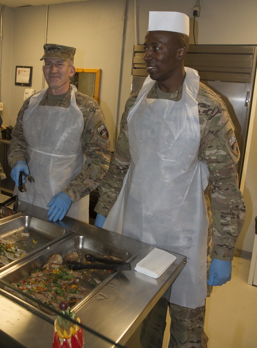 Gen. John Nicholson and Command Sgt. Maj. David M. Clark serve Thanksgiving lunch