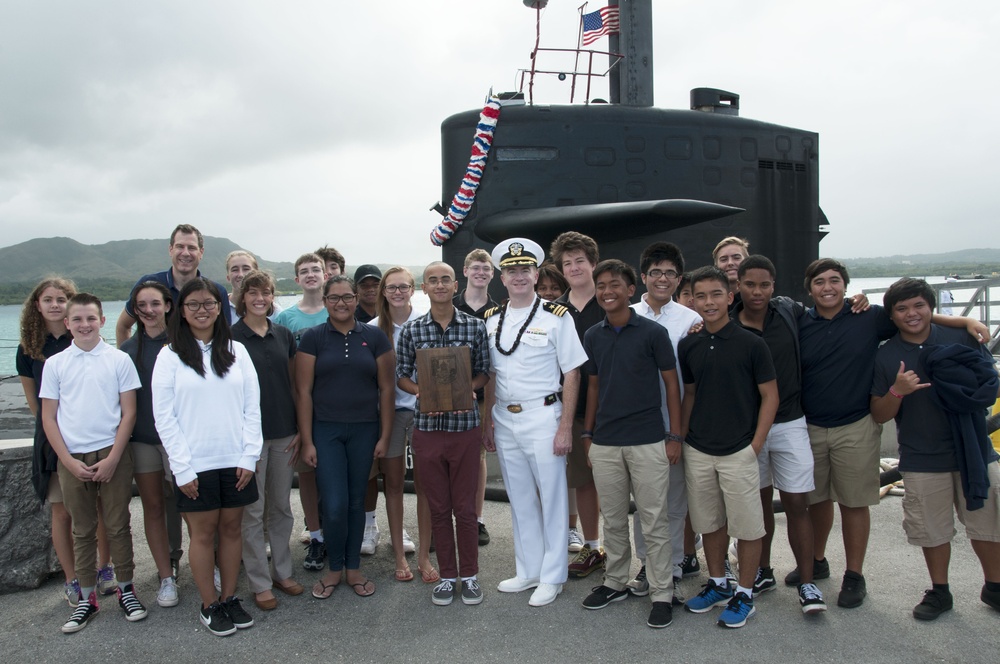 Cmdr. O'Donnell presents a command plaque to the Guam High School as USS Oklahoma City (SSN 723) Returns to Guam Dec. 8, 2016