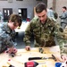 Pfc. Gabrielle F. Coppedge, left, and Spc. Steph Jones, right, work together to wire a three-way switch