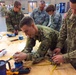 Sgt. Justin C. Payzant and Spc. Steph Jones put the finishing touches on wiring for a light
