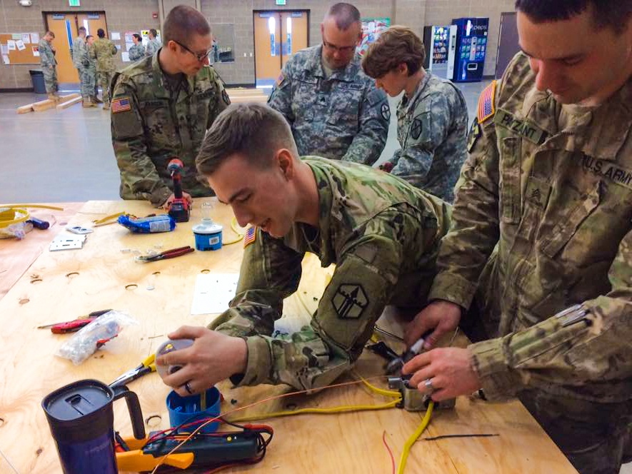 Sgt. Justin C. Payzant and Spc. Steph Jones put the finishing touches on wiring for a light