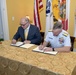 Coast Guard Rear Adm. Peter Brown and Mark Rosenburg sign a Memorandum of Agreement