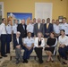 Coast Guard Rear Adm. Peter Brown and Mark Rosenburg pose for a group picture after signing a Memorandum of Agreement
