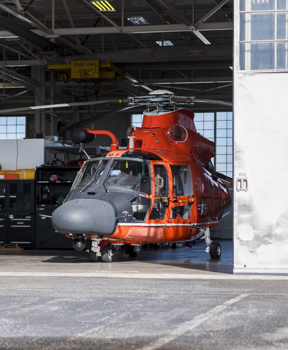 A Coast Guard MH-65 Dolphin helicopter stands ready inside Forward Operating Base Point Mugu