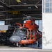 A Coast Guard MH-65 Dolphin helicopter stands ready inside Forward Operating Base Point Mugu