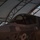 Lightning II strikes Iwakuni, F-35B arrives A pilot is seated in the cockpit of a military jet aircraft, identified by markings as a U.S. Marine Corps or Navy F-35, numbered '07', inside a semi-open hangar structure. The pilot is wearing a flight helmet and appears to be conducting pre-flight checks or cockpit familiarization. The image is taken in low-light conditions, giving it a dark, moody appearance.
