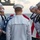 170117-N-BL637-034 A group of U.S. Navy sailors in dress white uniforms stand in a solemn formation around a flag-draped casket or body board on the deck of a naval vessel at sea. This appears to be a burial at sea ceremony, a formal military funeral tradition. The sailors have their heads bowed in a moment of prayer or reflection.