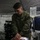 2d Medical Bn Field Exercise A U.S. Marine in MARPAT camouflage uniform is performing medical treatment on a simulated casualty (manikin) inside a military field medical tent. The scene depicts a combat casualty care training exercise, with IV fluids, medical tubing, and simulated wounds visible. The setting appears to be a forward surgical or aid station environment used for tactical combat casualty care (TCCC) training.