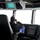 170120-N-OH262-547 A person wearing a black beanie and dark jacket is seated in a captain's chair on a ship's bridge, looking through binoculars out the forward windows. The bridge is equipped with multiple navigation displays including radar screens, electronic chart systems, and overhead instrument panels. The exterior view through the windows appears overcast or foggy with a bright white sky.
