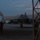 Lightning II strikes Iwakuni, F-35B arrives A military jet aircraft, identifiable as an F-35 Lightning II, is being marshaled on a flight line apron during dusk or dawn conditions. A ground crew member is using green glow sticks to guide the aircraft, which is taxiing between portable shelter structures. The low-light environment creates a dark, blue-toned atmosphere with the aircraft's navigation lights visible.