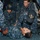 170117-N-DS065-0029 U.S. Navy personnel aboard USS Iwo Jima (LHD 7) are conducting a medical casualty training drill. Several sailors in Navy Working Uniforms (NWU) are practicing first aid and patient stabilization techniques on a simulated casualty lying on the deck. The scene depicts a realistic training exercise with simulated injuries visible on the patient.