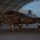 Lightning II strikes Iwakuni, F-35B arrives A U.S. Marine Corps F-35B Lightning II stealth fighter jet is parked under an arched hangar structure at dusk or dawn. The aircraft bears markings indicating it belongs to VMFA-121 (Marine Fighter Attack Squadron 121), with the number '07' visible on the fuselage. Ground crew personnel are visible on the left side of the aircraft, and the jet's navigation/position lights are illuminated in green.