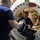 170123-N-TI693-075 Two individuals are interacting at the circular hatch entrance of what appears to be a hyperbaric or decompression chamber. One person is seated inside the chamber opening while another stands outside holding equipment, both appearing to be in good spirits. A red warning sign is visible above the hatch indicating fire and explosive hazard restrictions.