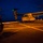 Marine leave USS Mesa Verde to conduct training A military tiltrotor aircraft, identified as an MV-22 Osprey marked '08', is parked on the flight deck of a naval vessel at night or dusk. Multiple military personnel in full combat gear are boarding or moving toward the aircraft. The rotors are spinning, indicated by motion blur and colored navigation lights (green and red) visible in the dark sky.