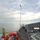 170120-N-OH262-798 The image shows the deck of the USNS Carson City (JHSV), a Joint High Speed Vessel operated by the United States Navy Sealift Command. The photograph is taken from an elevated position on the ship, looking forward along the vessel's distinctive wave-piercing catamaran hull design. The ship is underway at sea under partly cloudy skies.