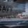 170123-N-MJ135-119 The image shows a U.S. Navy E-2C Hawkeye aircraft (Bureau Number 165648) assigned to VAW-116, embarked on USS Theodore Roosevelt (CVN-71) as part of Carrier Air Wing 17 (CVW-17), on the flight deck of the carrier. The aircraft is chained down to the deck and surrounded by numerous flight deck personnel in various colored jerseys indicating different roles. A yellow aircraft tow tractor is visible in the background.