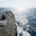 170121-N-KB426-052 The image shows the deck of a U.S. Navy Arleigh Burke-class guided-missile destroyer underway at sea. The view is taken from an elevated position on the ship's superstructure, looking forward along the starboard side. The vessel is cutting through open blue ocean under partly cloudy skies with visible wake trailing behind.