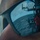170123-N-VN584-459 A close-up photograph of a person wearing mirrored sunglasses, with the lens reflecting a naval or coast guard vessel at sea. The reflection captures the ship's superstructure, railings, deck equipment, and crew members, including one person in a red shirt. The creative composition uses the sunglass lens as a mirror to reveal the maritime environment surrounding the subject.