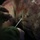 2d Medical Bn Field Exercise A close-up image showing a person's hands using a needle and what appears to be a small clamp or forceps tool on a large piece of raw meat or animal carcass. The surface of the meat shows visible markings including blue and red stamps, which are typical of official inspection or grading marks found on butchered livestock. The image is taken in low-light conditions with a shallow depth of field.