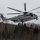 HMH-464 Marines Conduct Flight Operations during Exercise Frigid Condor A U.S. Marines CH-53E Super Stallion heavy-lift helicopter is captured in low-altitude flight over a snow-covered forested landscape. The aircraft bears 'MARINES' markings and appears to be operating in a cold-weather environment, likely during a training exercise. The rotors are in motion, indicating active flight at low elevation above the treeline.