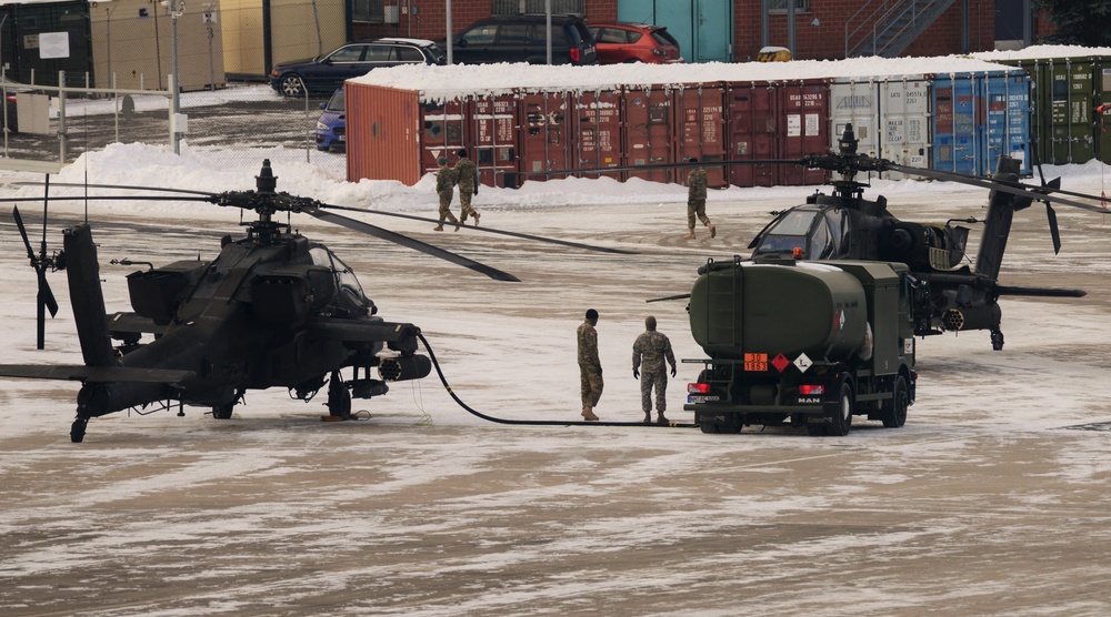 On a cold, windy afternoon, Soldiers from 1st Battalion, 3rd Aviation Regiment (Attack Reconnaissance), 12th Combat Aviation Brigade, refuel a AH-64 Apache helicopter Jan.