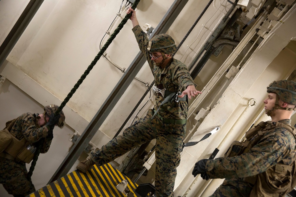 Marines fast rope while on ship