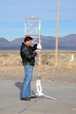 Jim Cutler, electronics engineer places the rocket on the launch pad
