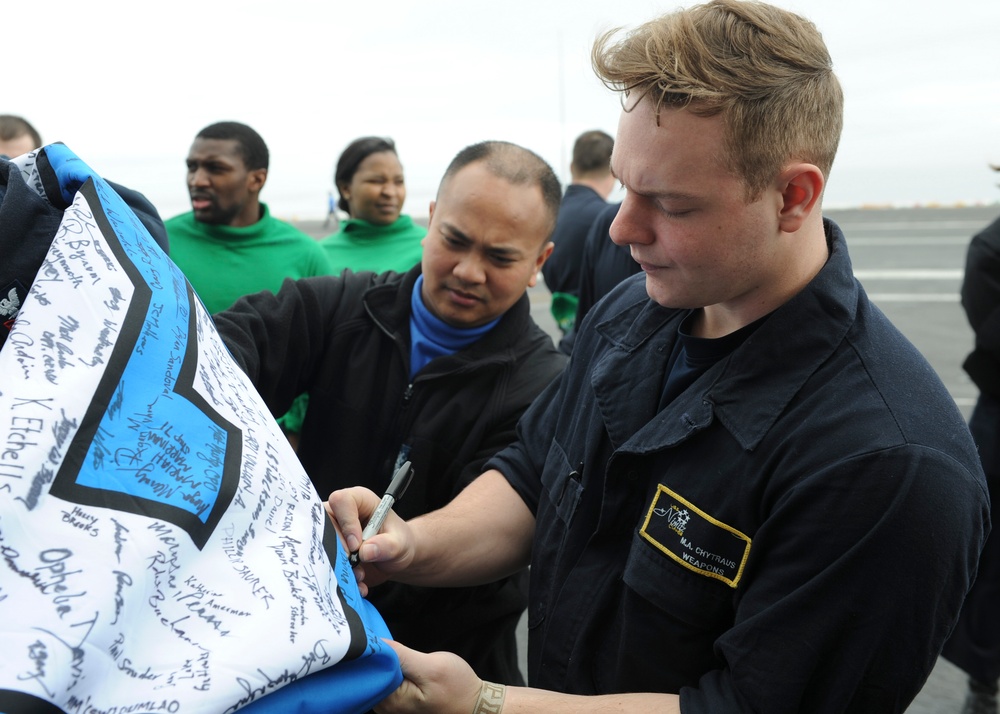 Nimitz Sailors pose with 12th man flag