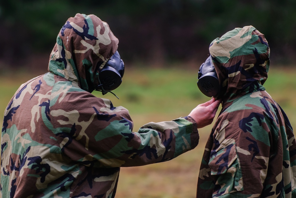 Two soldiers from Headquarters and Headquarters Company, 301st Maneuver Enhancement Brigade, inspect the other’s Joint Service Lightweight Integrated Suit Technology