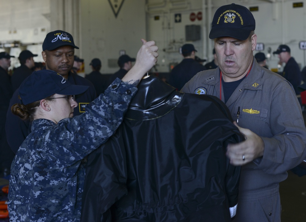 Inspector reviews wetsuit during demonstration
