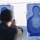 170215-N-JI086-110 A person is aiming a handgun at paper shooting targets during what appears to be a firearms qualification or training exercise. Two TSR-II transitional paper targets are visible, with the right target showing approximately 15-20 bullet holes concentrated in the torso area. The setting appears to be an outdoor range, possibly on a naval vessel given the water visible in the background.