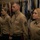 CMC awards Reserve Career Planner of the Year A group of United States Marine Corps personnel stand at attention in service uniform (Charlie/Delta) during what appears to be a formal military ceremony or formation. Multiple service members are visible in a line, wearing tan/khaki uniforms with ribbons and rank insignia. The background features a display of multiple military and state flags.