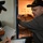 Inspector corrects discrepancies The image shows what appears to be a military inspection or inventory check aboard a naval vessel. A civilian or senior official wearing a black cap is using a flashlight to inspect a compartment labeled '3-194-2-A / FR 194-196 / S5', while uniformed U.S. Navy personnel record information on clipboards. The scene suggests a formal audit, survey, or readiness inspection.