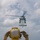 170213-N-WV703-117 A flight deck crew member in yellow safety gear is directing a military helicopter during a landing or departure operation on what appears to be a naval vessel at sea. The crew member, viewed from behind, is using hand signals to communicate with the helicopter crew. The scene takes place on an open flight deck with ocean visible in the background.