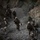1st Battalion, 3rd Marines tear up Range 400 A patrol of armed military personnel in desert camouflage uniforms moves through a rocky mountain canyon or ravine. The soldiers are navigating a narrow, gravel-strewn trail flanked by steep rock faces. The formation suggests a tactical movement through rugged, arid terrain.