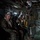 Group Sails Military personnel, appearing to be U.S. Marines based on their MARPAT digital camouflage uniforms, are seated inside the cargo bay of a military helicopter or transport aircraft. A crew member wearing a flight helmet and flight suit stands over the seated personnel, appearing to brief or check on them. The personnel are equipped with hearing protection, goggles, and tactical gear consistent with an airborne insertion or transport operation.
