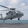 170213-N-WV703-098 A U.S. Navy MH-60 Seahawk helicopter, marked with the number '45', is hovering or taking off from the flight deck of a naval vessel at sea. The helicopter is in a low hover above the ship's landing pad with its rotor blades in motion, creating visible blur. The background shows open ocean water and a partly cloudy sky.