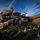 1st Battalion, 3rd Marines tear up Range 400 A U.S. Marine in desert MARPAT camouflage is firing a machine gun from a prone position behind sandbags. A spent brass casing is visibly ejecting from the weapon mid-fire. Numerous expended shell casings and links are scattered across the foreground, indicating sustained fire during what appears to be a training exercise.