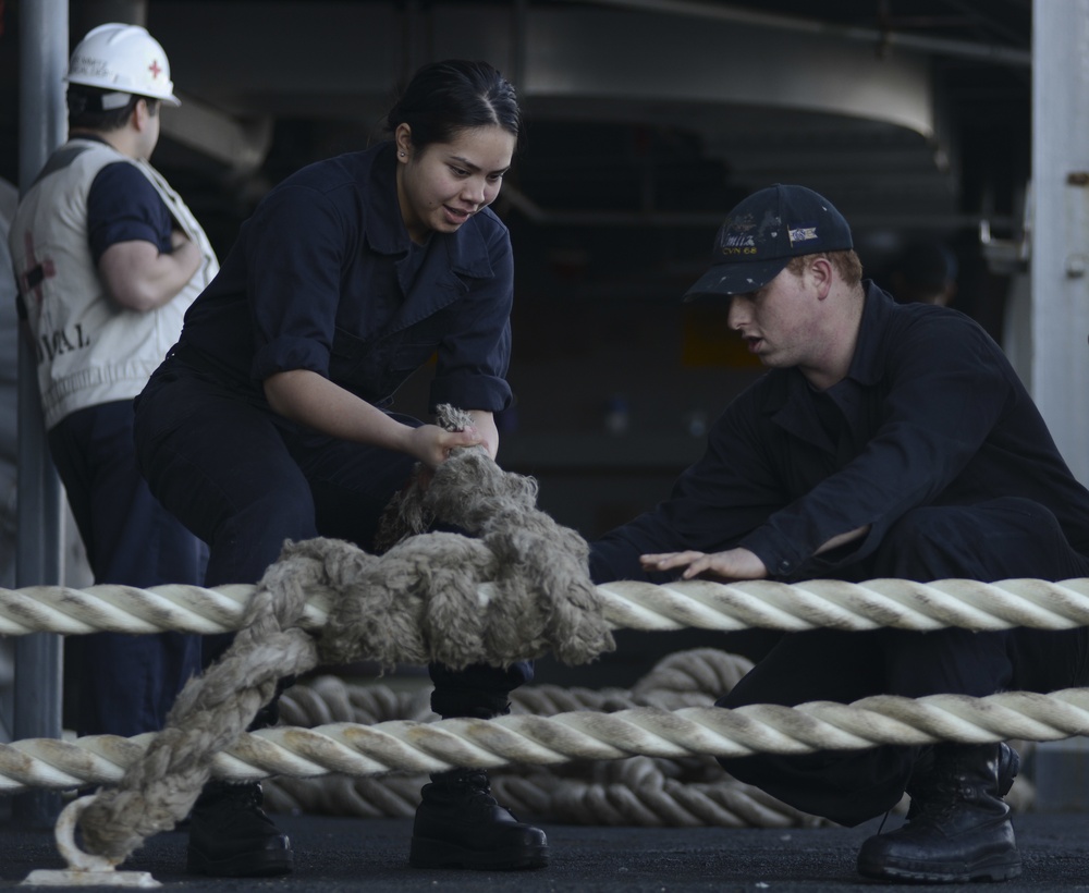 Sailors tie stopper onto mooring line