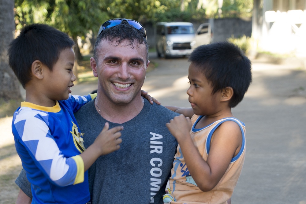 Members of the 353rd Special Operations Group help children in the Phillipines