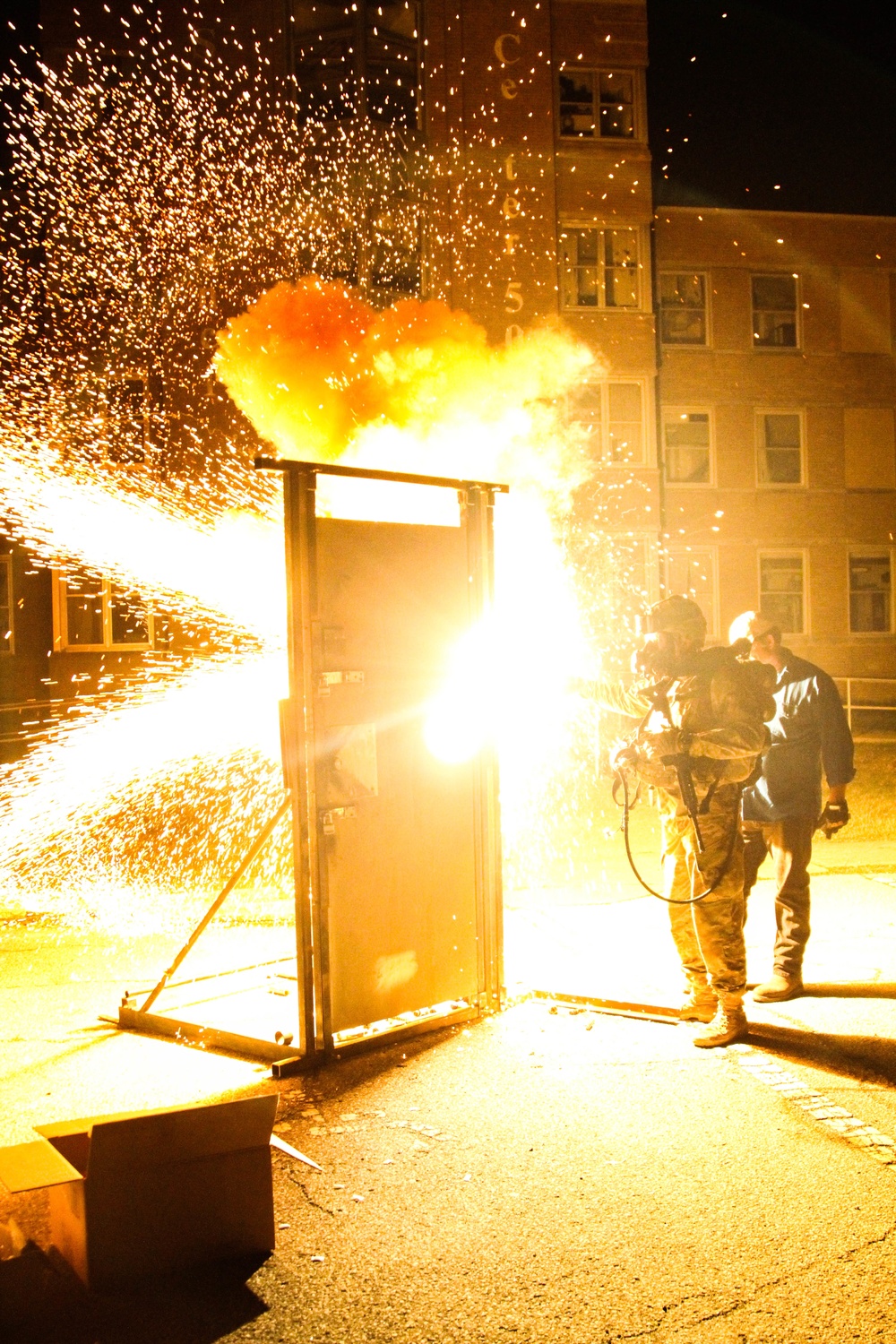 Paratrooper cuts through a steel door with a Tech Torch while wearing the Subterranean Breathing Aperatus (STBA)