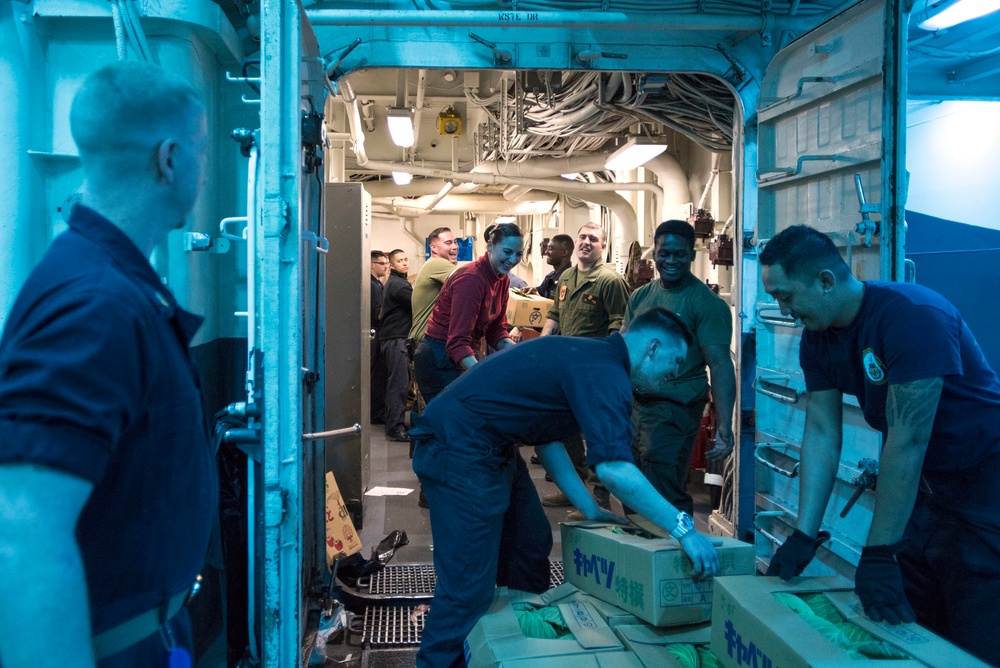 USS Bonhomme Richard (LHD 6) conducts nighttime replenishment at sea