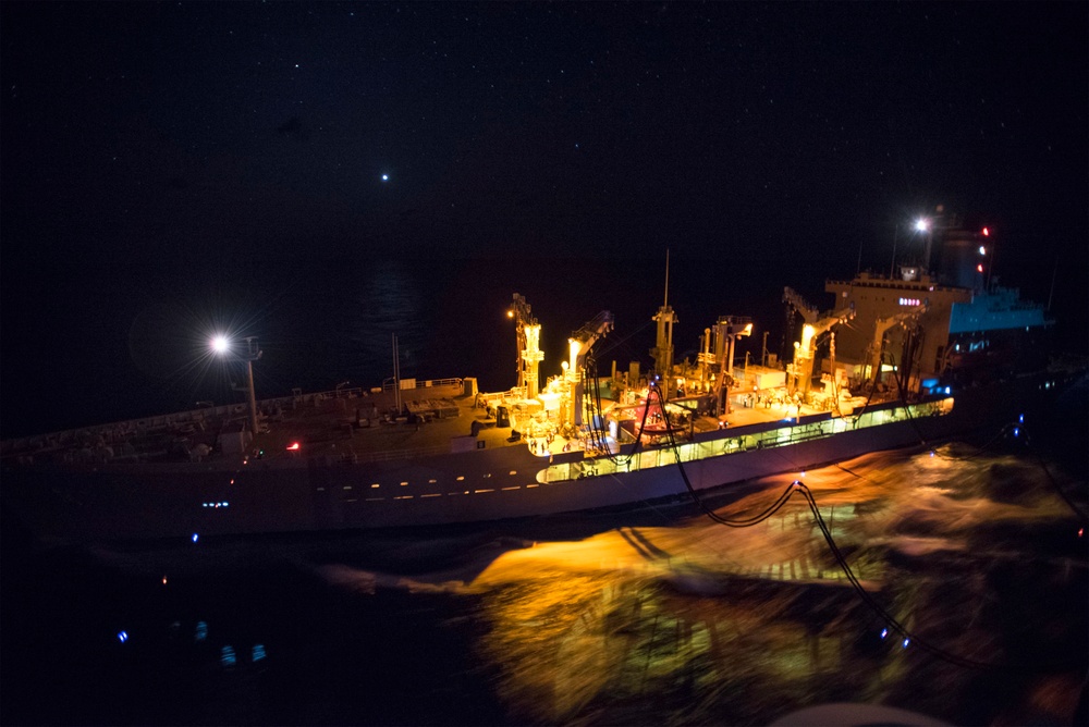 USS Bonhomme Richard (LHD 6) conducts nighttime replenishment at sea