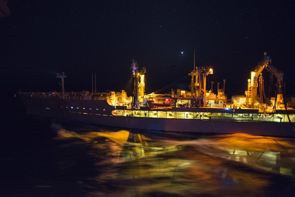 USS Bonhomme Richard (LHD 6) conducts nighttime replenishment at sea